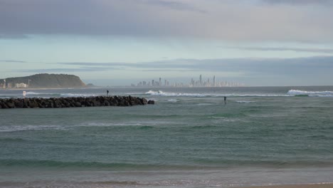 Surfers-Riding-On-The-Sea-Waves-In-Currumbin-Beach---Surfing-In-Gold-Coast,-Queensland---wide-shot