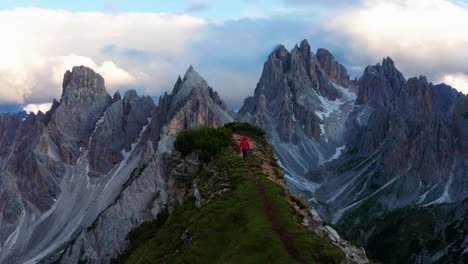 Man-walking-to-Dolomites-cliff-in-Italy,-revealing-epic-landscape