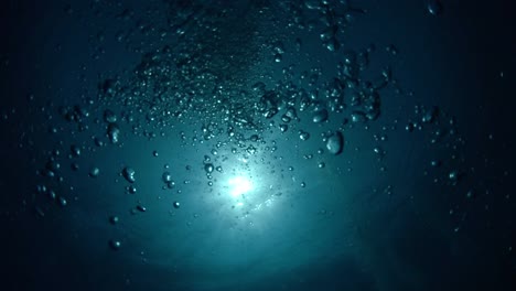 Unter-Wasser-Mit-Blick-Auf-Den-Sonnenball-Mit-Luftblasen,-Die-An-Die-Oberfläche-Steigen