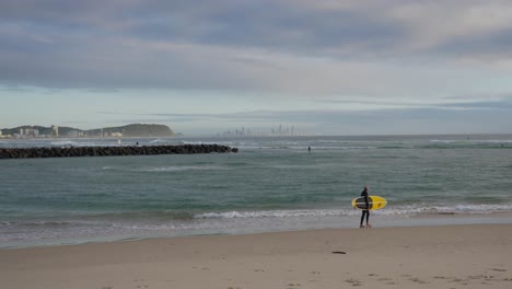 Surfer-With-Surfboard-Walking-On-The-Shore-Of-Currumbin-Beach---Surfing---Gold-Coast,-Queensland,-Australia