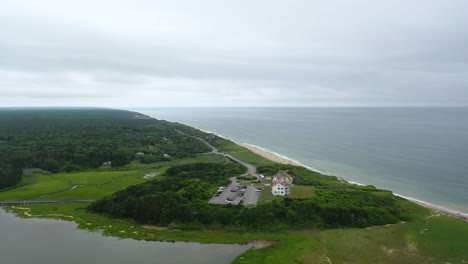 Ominous-Aerial-Drone-Footage-Beach-and-Ocean-on-Dark-Cloudy-Day-in-Cape-Cod,-Massachusetts-with-Parking-Lot-and-Marsh