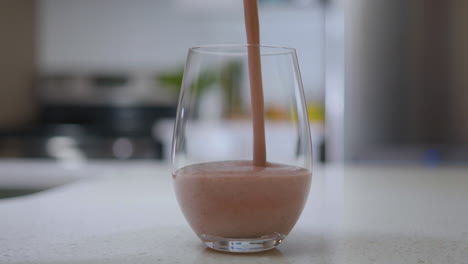 Pouring-a-smoothie-into-glass-with-stainless-steel-straw