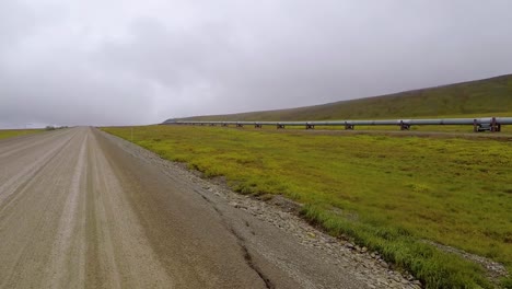 POV-view-driving-on-the-Dalton-Highway,-following-the-Alyeska-pipeline,-on-a-dark,-gloomy,-autumn-day,-in-Alaska,-USA