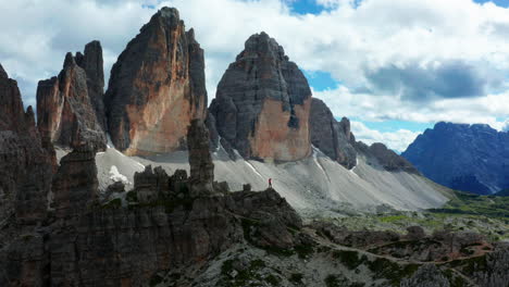 Triumphant-man-stands-on-cliff,-Italy-Dolomites-in-distance