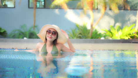 Zufriedene-Stilvolle-Asiatische-Dame,-Die-An-Heißen-Sommertagen-Im-Wasser-Des-Schwimmbades-Genießt
