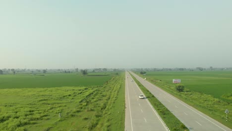 Amazing-aerial-view-of-the-well-organized-agricultural-land-divided-by-the-express-highway-in-Punjab-province,-INDIA
