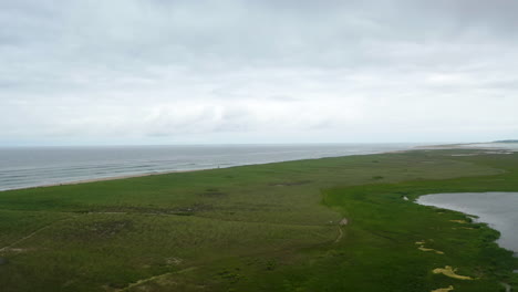 Aerial-Drone-Shot-of-Ocean-and-Marsh-on-Dark-Cloudy-Day-in-Cape-Cod,-Massachusetts,-Pan-Right