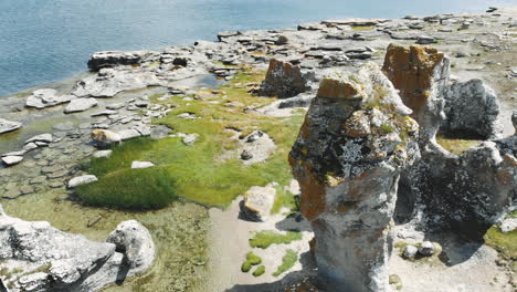 Drone-orbit-around-tall-sea-stacks-or-Rauks,-Gotland-coastline,-Sweden