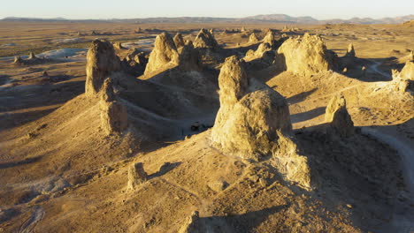 Aerial-view-looking-down-at-the-Trona-Pinnacles-in-the-Mojave-Desert-during-a-bright-yellow-sunset