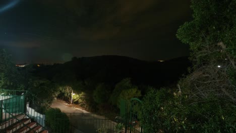 Nachthimmel-Zeitraffer-Einer-Leeren-Straße-Mit-Einem-Hügel-Im-Hintergrund
