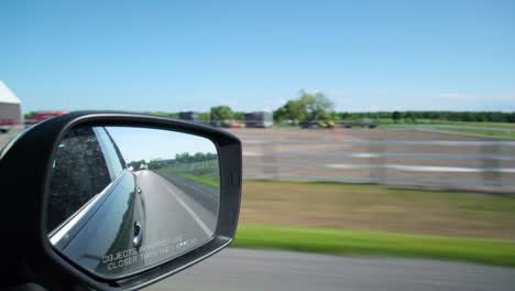 View-from-the-side-mirror-to-the-dash-view-from-a-moving-car-in-Prince-Edward-County