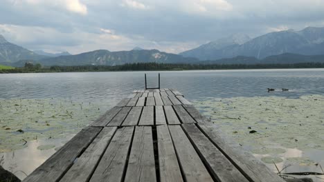 Wooden-Jetty-at-Lake-Hopfensee-near-Fuessen-with-Mountains-in-the-Background,-Bavaria,-Germany
