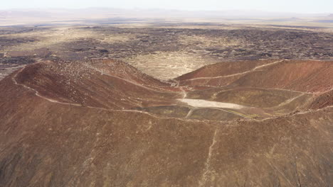 Vista-Aérea-Volando-Hacia-Y-A-Través-Del-Cráter-Volcánico-Amboy-En-El-Desierto-De-Mojave