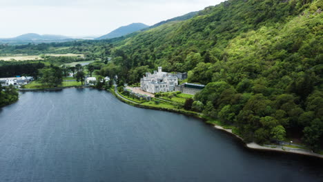 High-angle-aerial-view-over-Kylemore-Abbey-and-surrounding-landscape