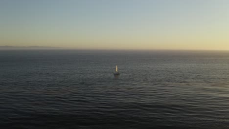 Segelboot-Allein-Im-Ozean-Während-Des-Wunderschönen-Malerischen-Sonnenuntergangs,-Aus-Der-Vogelperspektive