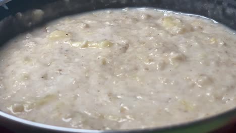Cooking-oatmeal-porridge-in-a-black-pot-in-slowmotion
