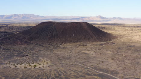 High-altitude-tilt-down-view-of-volcanic-Amboy-Crater-and-the-dirt-road-leading-away