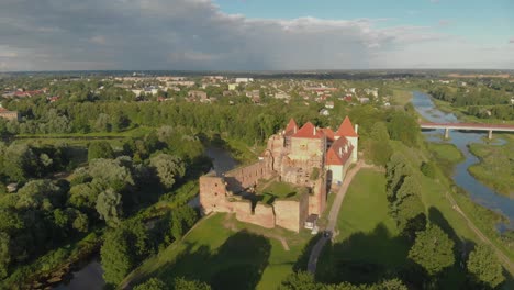 Panoramic-aerial-of-Bauska-castle-and-city-in-Latvia-at-golden-hour