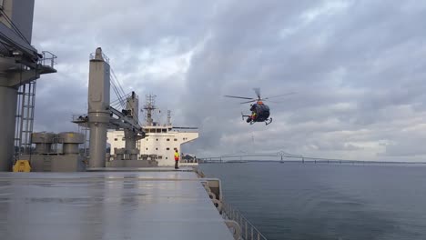 Helicopter-getting-close-to-the-deck,-pilot-disembarking-operation-at-open-sea