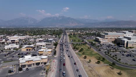 Aerial:-Riverton-city-roads-and-hospital-in-Utah,-Wasatch-Range-in-background