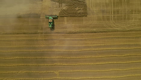 Harvesting-Machine-Moving-Around-The-Field-In-Kielno-Poland-During-Daytime---Aerial-Shot