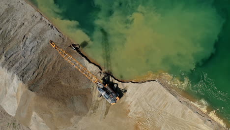 Top-down-view-of-an-excavator-loading-sand-into-the-water