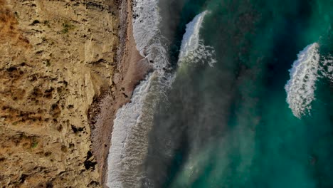 Meereswellen,-Die-An-Felsiger-Küste-Spritzen-Und-Schäumen,-Meereslandschaft-Mit-Braunen-Türkisfarbenen-Farben