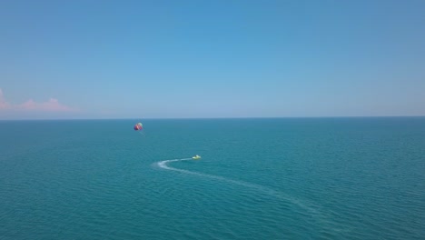 Parasailing---Barco-Con-Paracaídas-Cruzando-Las-Tranquilas-Aguas-Azules-Durante-El-Verano-En-Grecia