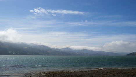 Impresionantes-Vistas-Del-Puerto-Y-La-Península-De-Dunedin-Con-Montañas-Cubiertas-De-Nubes-Y-Pequeñas-Olas