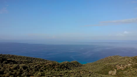 Colinas-Verdes-Con-Terrazas-De-Olivos-Sobre-El-Interminable-Mar-Jónico-Azul-Bajo-Un-Cielo-Brillante