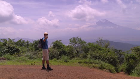 Excursionista-Masculino-Solo-Tomando-Selfies-En-La-Cima-De-La-Montaña-Mirando-Hacia-El-Monte-Fuji