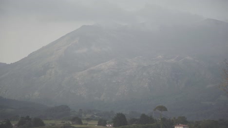 Green-landscape,-foggy-mountains-at-the-background,-Asturias,-Spain,-static-shot