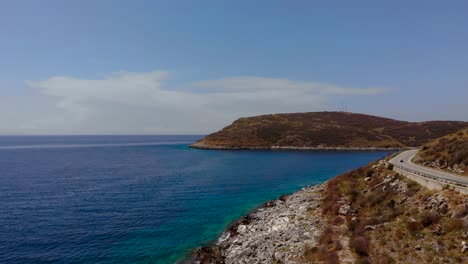 Colorful-seaside-in-Mediterranean-with-blue-turquoise-sea-washing-rocky-slope-of-hills-alongside-panoramic-road