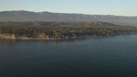 Drone-Flies-Over-Pacific-Ocean-toward-California-Coast-on-Summer-Evening