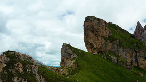 Man-in-distance-climbs-to-edge-of-Seceda-cliff-in-Italy's-Dolomites