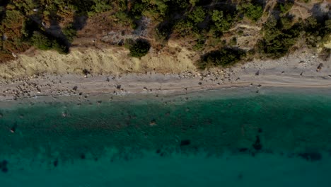 Unberührte-Küstenlinie-Mit-Felsigem-Strand,-Der-Von-Ruhigem,-Sauberem-Meerwasser-In-Smaragdgrünen-Farben-Umspült-Wird