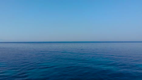 Blue-azure-water-of-open-sea-and-clear-bright-sky-at-summer-sunny-day,-copy-space-for-vacation-texture