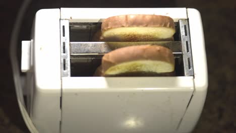 Zwei-Scheiben-Weizenbrot,-Die-Aus-Einem-Weißen-Toaster-Herausspringen