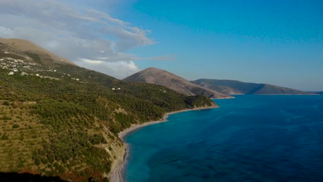 Beautiful-seascape-with-green-hills-full-of-citrus-terraces-and-villages-above-blue-turquoise-sea-water-in-Albania