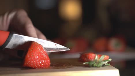 Frau-Hände-Schneiden-Rote-Erdbeeren-Auf-Holzbrett-Mit-Einem-Scharfen-Messer
