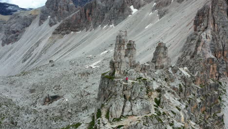 Man-climbing-Dolomites-Cliffs-in-Red-Jacket,-Italy