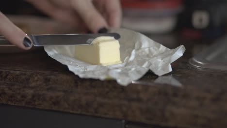 Slicing-Butter-Using-Stainless-Bread-Knife-With-A-Blurry-Background