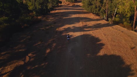 Aerial-view-of-backpacker-running-on-a-dirt-trail