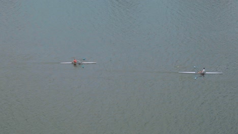 Group-of-speed-kayakers-on-Vltava-river-in-Prague-at-Vysehrad-fortress,-slow-motion-aerial-view