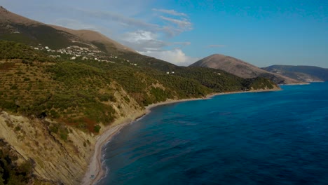 Paraíso-Costero-Mar-Azul-Lavando-Ladera-Rocosa-De-Colinas-Y-Pueblos-Turísticos-Con-Vista-Al-Mar-En-Albania