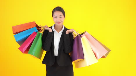 Junge-Asiatische-Geschäftsfrau,-Die-Bunte-Einkaufstaschen-In-Den-Händen-Und-Im-Glück-Hält