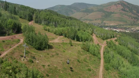 Aerial-footage-over-the-Gondolas-in-Vail-Colorado,-while-mountain-biker-make-their-way-down-the-mountain