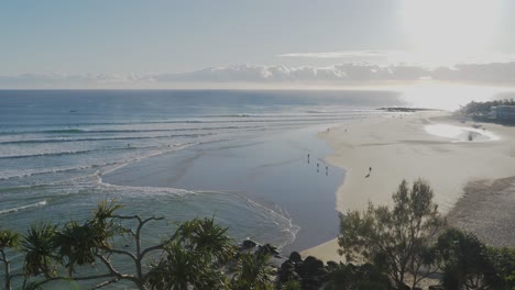 Menschen,-Die-Bei-Einem-Sonnenaufgang-Am-Strand-Von-Snapper-Rocks-Spazieren-Gehen---Wellen-Auf-Dem-Blauen-Ozean---Rainbow-Bay---Gold-Coast,-Queensland,-Australien
