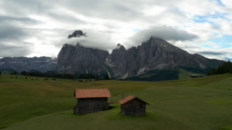 Cabañas-Italianas-En-La-Meseta-Alpina-Con-Dolomitas-En-La-Distancia