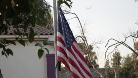 Bandera-Estadounidense-Ondeando-Alto-Y-Orgulloso-En-El-Asta-De-La-Bandera-Fuera-De-La-Escuela-Primaria,-Cámara-Lenta